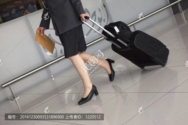 機場。女人的腿和旅行箱