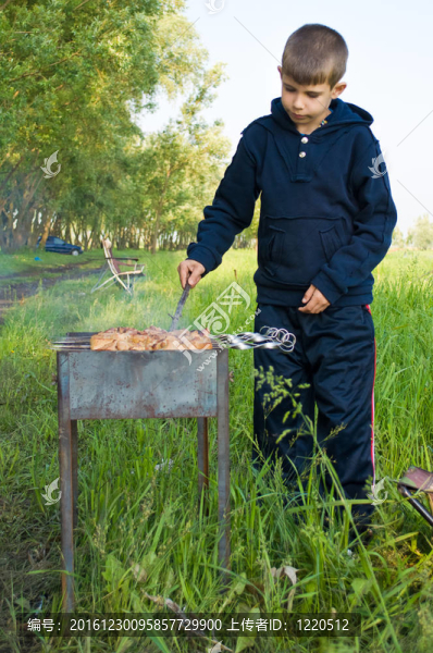 這個(gè)男孩正準(zhǔn)備烤肉