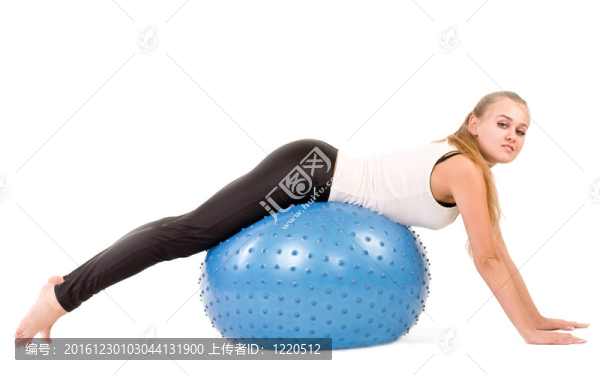 年輕女子在健身房與一個(gè)藍(lán)色的球