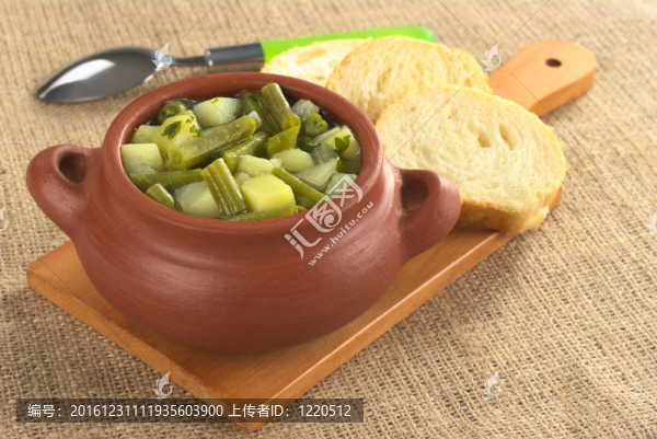 綠豆和質(zhì)樸的碗土豆羊肉在木制板面包片和勺子在后面建立黃麻（選擇性聚焦；在火鍋上半年重點(diǎn)）