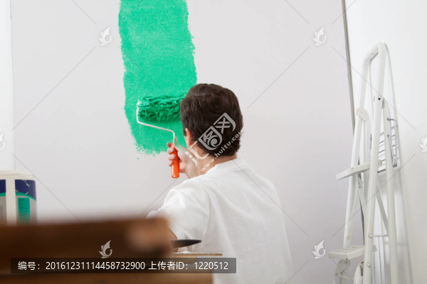 用滾筒畫墻的人
