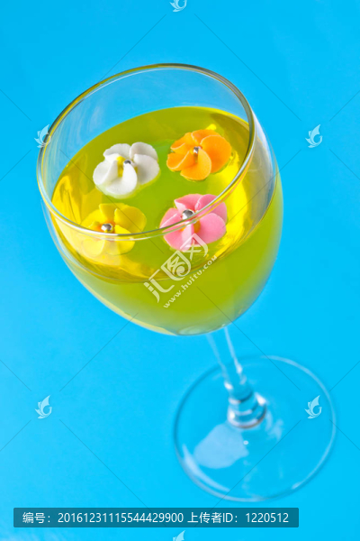 在藍(lán)色背景上有黃色果凍的玻璃杯里的糖