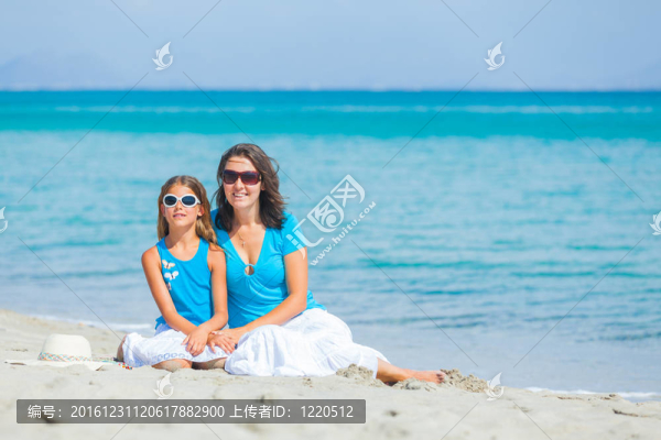 母親和她的小女兒在海灘上