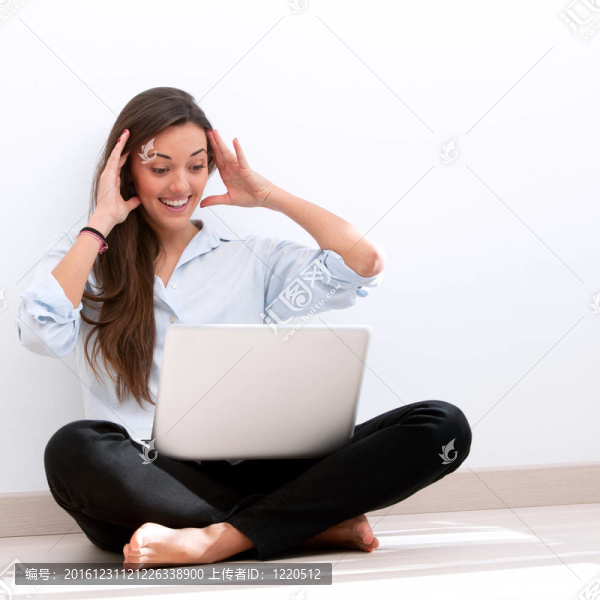 女孩坐在地板上與筆記本電腦