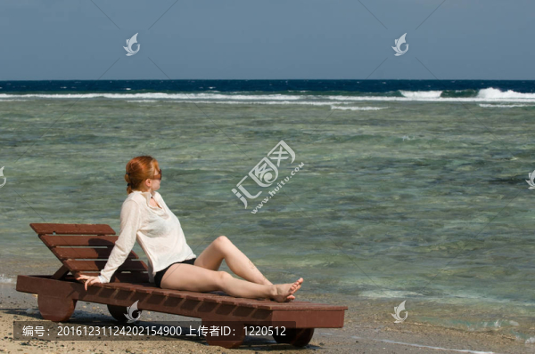 美麗的紅女人在海邊放松