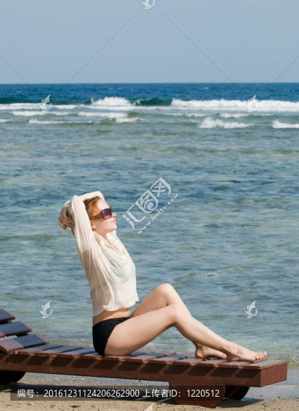 美麗的紅女人在海邊放松