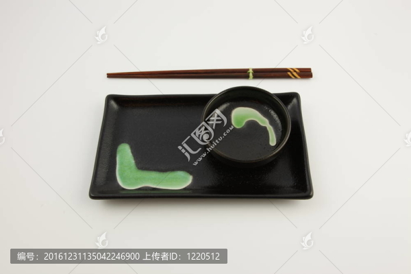 一個(gè)綠色和黑色的壽司板與筷子