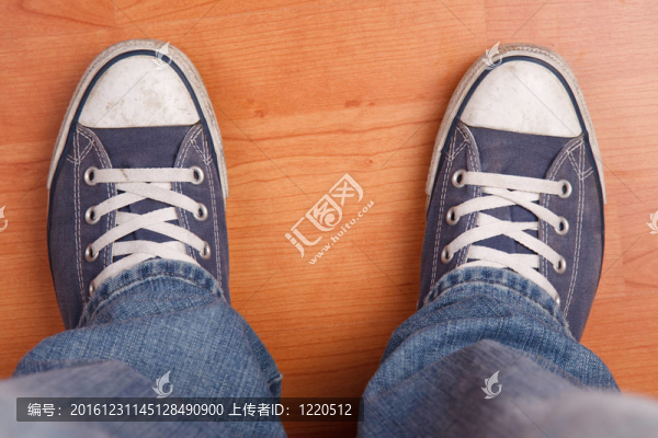 帶牛仔褲和運動鞋的人的腳