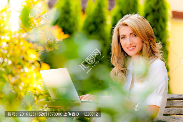 花園里帶筆記本電腦的女人