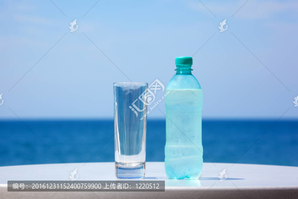 在大海的天空下，桌上的水和玻璃瓶。