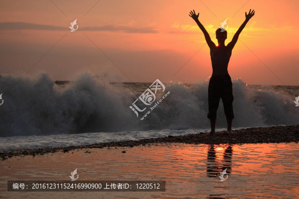 剪影家伙舉起手在日落波浪海灘