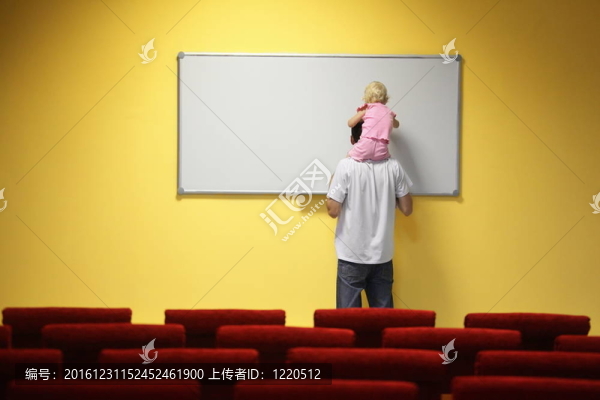小女孩正坐在父親的脖子上畫畫。焦點外椅。