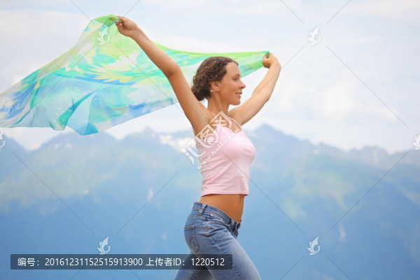 美麗快樂的女人的頭巾。背景山脈。