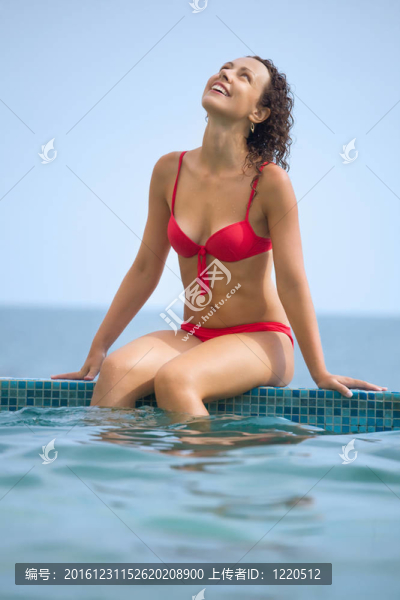 年輕美麗的性感女子坐在窗臺池海上度假