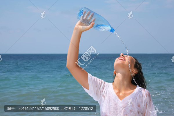 美麗的女人從瓶上澆水海岸；閉上眼睛