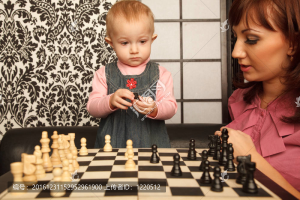 在棋盤的母親和她的小女兒。橫向格式。室內(nèi)的.