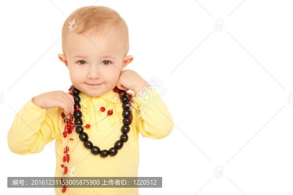 微笑的小女孩在白色背景上的黃色襯衫上看著相機(jī)。