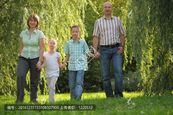 爸爸；媽媽；兒子和女兒在初秋公園散步。