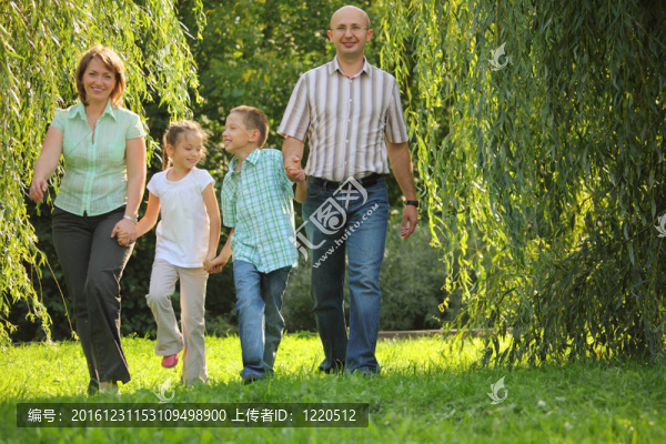 帶兩個(gè)孩子的微笑家庭。父親；母親；兒子和女兒在初秋公園散步。