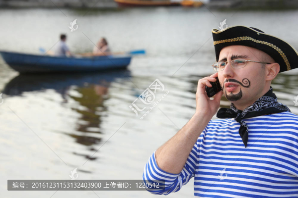穿海盜服的男子正在用電話交談。船外焦