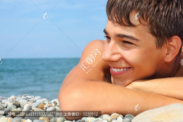 十幾歲的男孩躺在多石的海岸；遠望