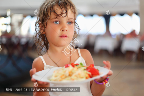 漂亮的小女孩手里拿著菜