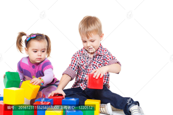 小孩子坐在地板上玩五顏六色的立方體