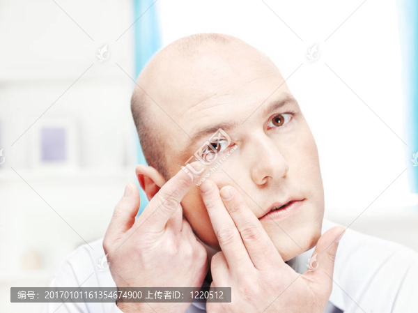 男子把隱形眼鏡在他的眼睛