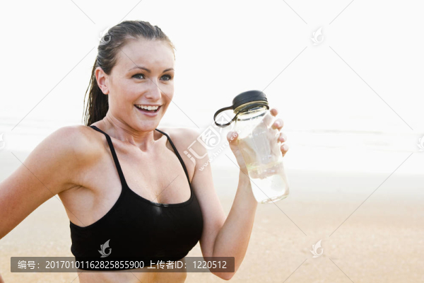 健康適合年輕女子在海灘飲用水