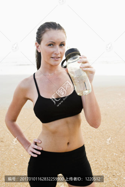 健康適合年輕女子在海灘飲用水