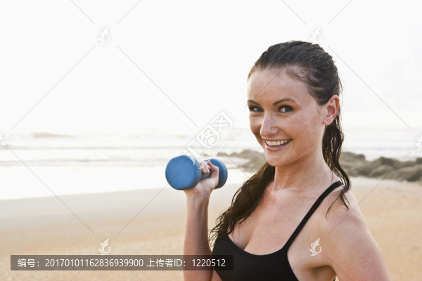 美麗的年輕女子在海灘上鍛煉