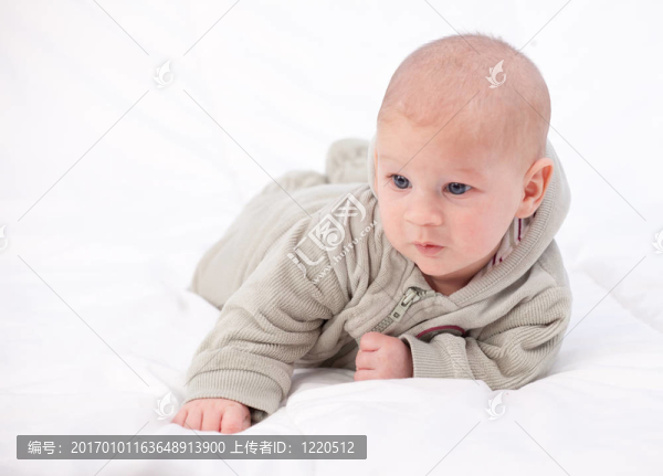 灰色運動衫躺在被子里兩個月大的男嬰