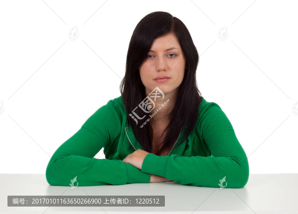 坐在憂郁的年輕的長頭發(fā)女人穿著綠色的襯衫