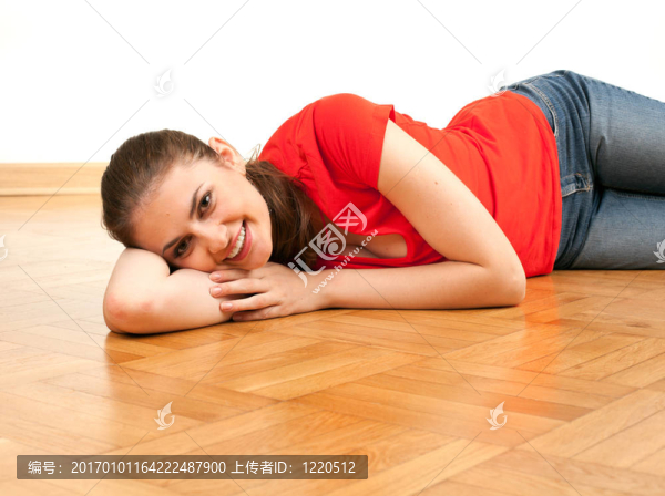 微笑的年輕女子躺在木地板上