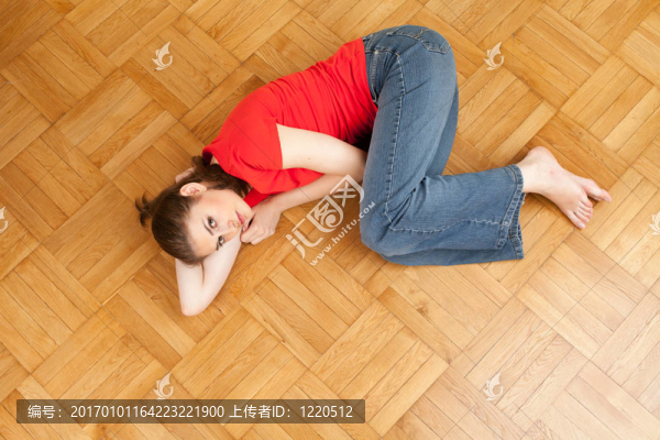 微笑的年輕女子躺在木地板上