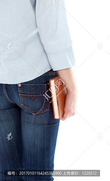站在牛仔褲的年輕女子手里拿著書