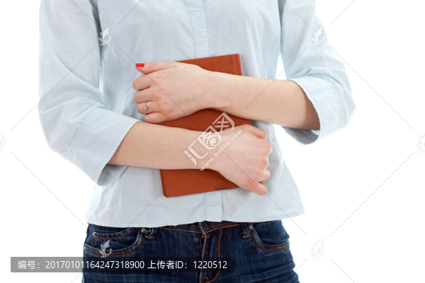 站在牛仔褲的年輕女子手里拿著書(shū)
