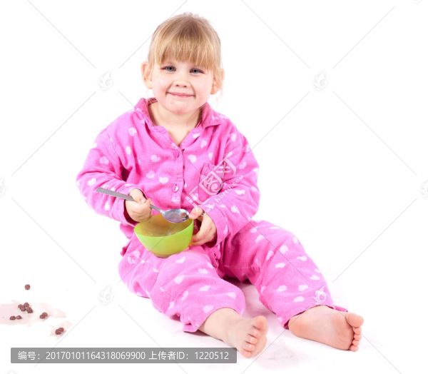 穿著粉色睡衣的小女孩吃麥片粥和牛奶