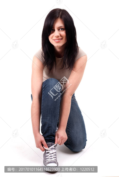 年輕女子綁著球鞋和微笑