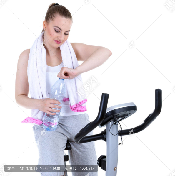 女人；帶著一瓶水；在固定的訓(xùn)練自行車上她想苗條
