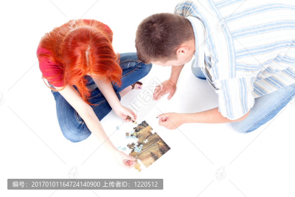 年輕夫婦玩拼圖在地板上