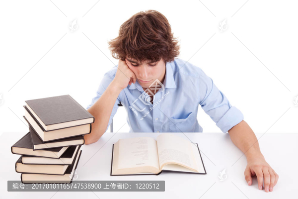 可愛的男孩在他的書桌上學(xué)習(xí)和閱讀一本書；白色的孤立的