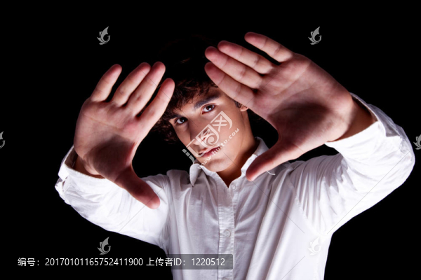 可愛的男孩舉起他的手；孤立的黑色背景；工作室拍攝
