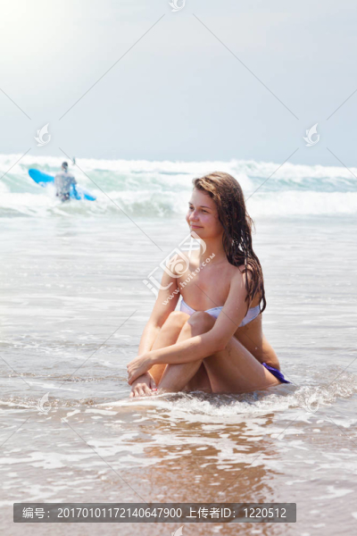 美麗的女孩在海岸上的海灘上曬黑