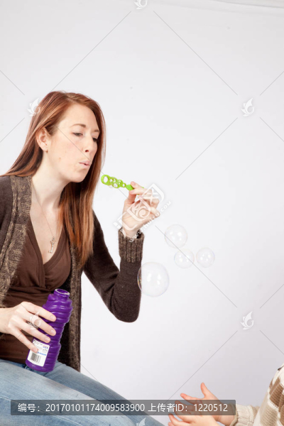 女人吹泡泡給男孩