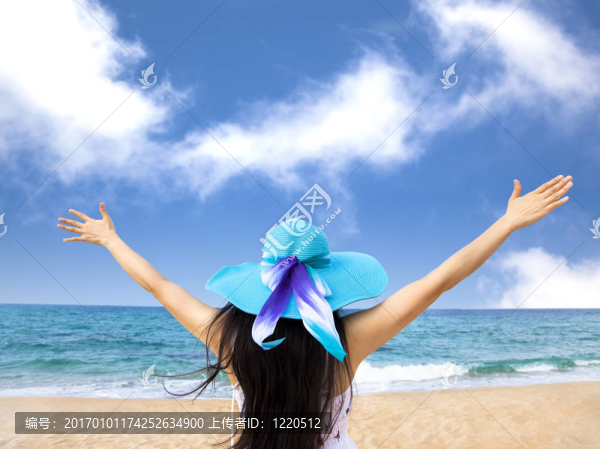 年輕的女人raiseher手在海灘