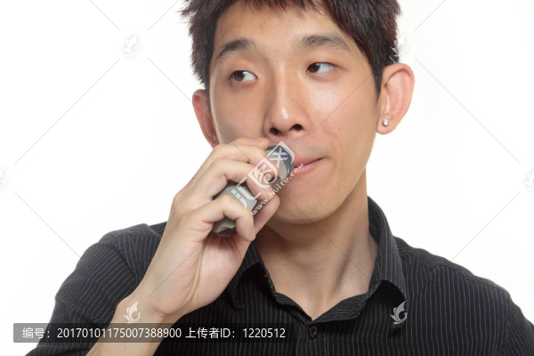 年輕人刮胡子用電動剃須刀