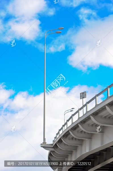 在藍天白云的背景與立交橋的燈柱
