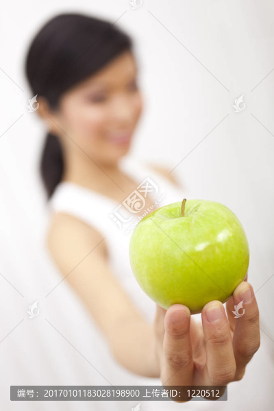 亞洲華裔女孩手持新鮮青蘋果相機