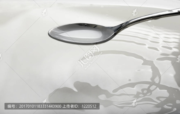 碗上裝滿牛奶的勺子
